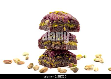 Pistazien lila Baklava auf weißem Hintergrund. Baklava speziell für Diabetiker vorbereitet. Traditionelle Köstlichkeiten der mediterranen Küche. Nahaufnahme Stockfoto