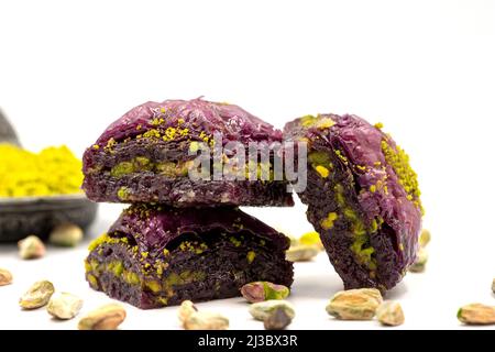 Pistazien lila Baklava auf weißem Hintergrund. Baklava speziell für Diabetiker vorbereitet. Traditionelle Köstlichkeiten der mediterranen Küche. Nahaufnahme Stockfoto