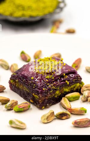 Pistazien lila Baklava auf weißem Hintergrund. Baklava speziell für Diabetiker vorbereitet. Traditionelle Köstlichkeiten der mediterranen Küche. Nahaufnahme Stockfoto