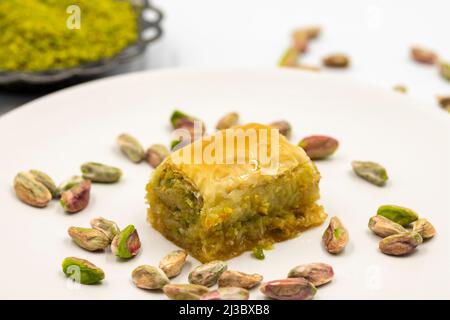 Baklava mit Pistazie auf weißem Hintergrund. Traditionelle mediterrane Küche, Delikatessen. Nahaufnahme Baklava Stockfoto