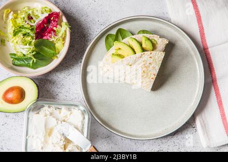 Kochvorgang für Sandwich und Zutaten. Prozess der Zubereitung von Quesadilla mit Avocado, Lachs, Quark und Spinat. Trendy Wrap Hack. Schritt für Schritt Stockfoto