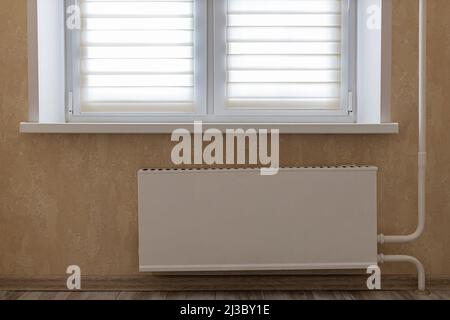 Zentralheizung Heizkörper befindet sich unter dem Fenster an der Wand Stockfoto