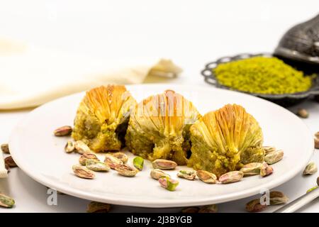 Muscheln Baklava auf weißem Hintergrund. Traditionelle mediterrane Spezialitäten. Nahaufnahme Pistazien Baklava. Lokaler Name midye Baklava Stockfoto