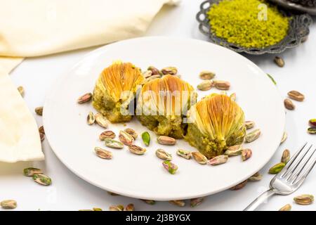 Muscheln Baklava auf weißem Hintergrund. Traditionelle mediterrane Spezialitäten. Nahaufnahme Pistazien Baklava. Lokaler Name midye Baklava Stockfoto