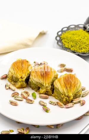 Muscheln Baklava auf weißem Hintergrund. Traditionelle mediterrane Spezialitäten. Nahaufnahme Pistazien Baklava. Lokaler Name midye Baklava Stockfoto