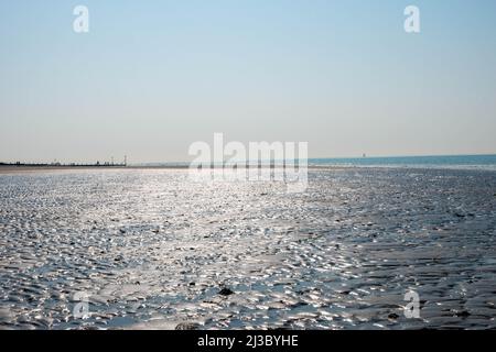 Wellen auf dem Sand, der durch den Wind über den Strand weht Stockfoto