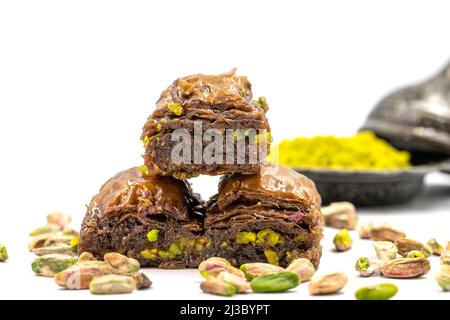 Schokoladenbaklava mit Pistazie auf weißem Hintergrund. Traditionelle Köstlichkeiten der mediterranen Küche. Nahaufnahme Schokolade Baklava. Lokaler Name cikolatal Stockfoto