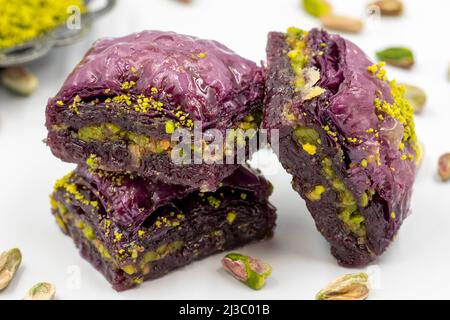 Pistazien lila Baklava auf weißem Hintergrund. Baklava speziell für Diabetiker vorbereitet. Traditionelle Köstlichkeiten der mediterranen Küche. Close up bakla Stockfoto