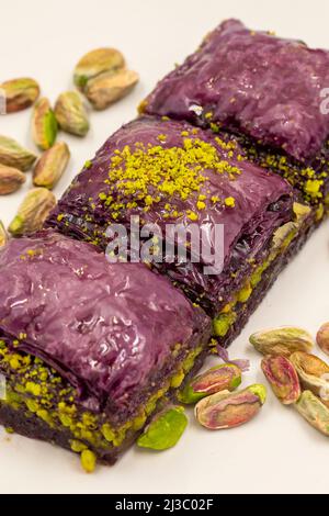 Pistazien lila Baklava auf weißem Hintergrund. Baklava speziell für Diabetiker vorbereitet. Traditionelle Köstlichkeiten der mediterranen Küche. Close up bakla Stockfoto