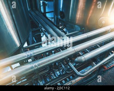 Große Stahltanks und -Rohre. Industriebrauerei-Rohrleitungen in abstrakter blauer Farbe. Branchenhintergrund. Stockfoto