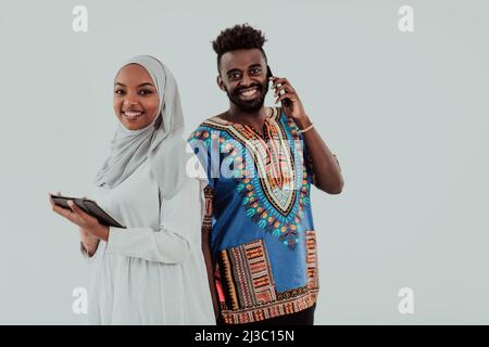 Junge afrikanische Business-Team Frau trägt traditionelle sudanesische muslimische Hijab-Kleidung mit Tablet-Computer isoliert auf weißem Hintergrund Studenten Paar Stockfoto