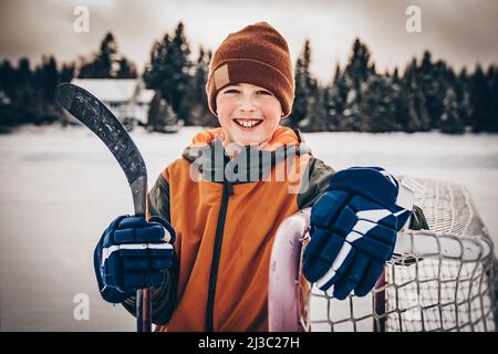 Porträt eines glücklichen Eishockeyspielers auf einem See Stockfoto