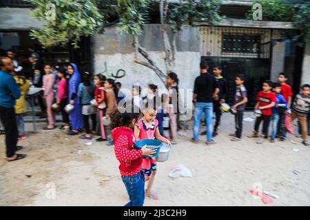 Gaza, Palästina. 06. April 2022. Gaza, Palästina - 6. April 2022, palästinensische Kinder wurden glücklich, nachdem sie im Flüchtlingslager Al-Nuseirat im zentralen Gazastreifen Suppe von einem Zentrum einer lokalen Wohltätigkeitsorganisation erhalten hatten, die während des heiligen Monats Ramadan kostenlose Nahrung anbietet. Muslime auf der ganzen Welt, vor allem im heiligen Monat Ramadan, bieten eine Menge von Wohltätigkeitsorganisationen wie kostenlose Mahlzeiten Verteilungszentren an, die sie als „Tekeya“ für arme Menschen bezeichnen. Kredit: SOPA Images Limited/Alamy Live Nachrichten Stockfoto