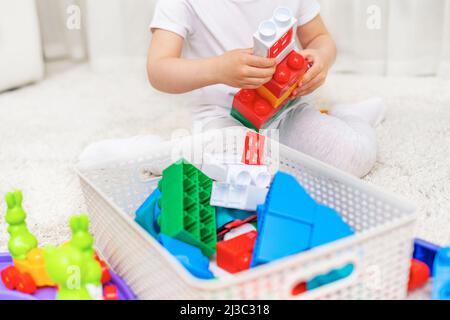Das Kind sammelt einen mehrfarbigen Konstruktor. Stockfoto