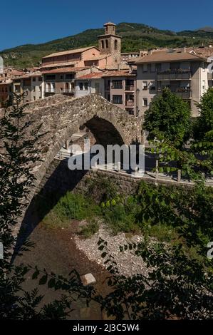 Die mittelalterliche Pont Vell oder Alte Brücke, die im 14.. Jahrhundert erbaut wurde, überspannt heute den Fluss Llobregat bei La Pobla de Lillet in Katalonien, Spanien, mit einem einzigen, anmutigen Eselrückenbogen, Aber es kann einmal zwei Bögen gehabt haben und die ashlar Fundamente der Säulen deuten darauf hin, dass seine Ursprünge römisch sein können. Stockfoto