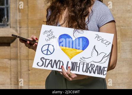 Demonstranten vor der Abtei von Bath halten Plakate und ukrainische Flaggen gegen den Krieg, während sie an einer Demonstration gegen die russische Invasion in der Ukraine teilnehmen Stockfoto