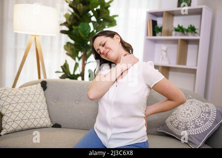 Nahaufnahme einer unglücklichen Frau, die zu Hause an Nackenschmerzen leidet Stockfoto