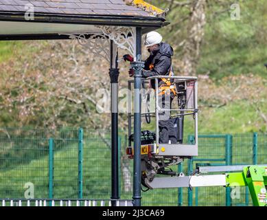 Arbeiter auf Kirschpflücker mit Sicherheitsgurt Lackierband stehen Metallarbeiten in Warminster, Wiltshire, Großbritannien am 7. April 2022 Stockfoto