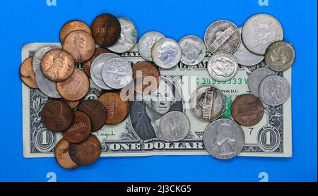 Foto einer amerikanischen Banknote mit einem Dollar, bedeckt mit alten gebrauchten Münzen, 1 Dollar Stockfoto