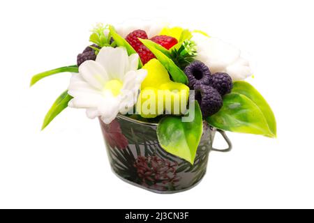 Handgemachte Seifenform aus Gänseblümchen und Beeren in einem Mini-Eimer aus Metall auf weißem Hintergrund. Stockfoto