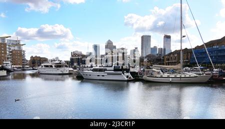 Boote, die im Limehouse Basin im Osten Londons mit den Bürogebäuden von Canary Wharf im Hintergrund festgemacht wurden. Stockfoto