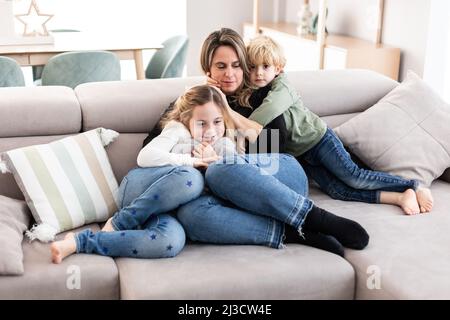 Schwarz-weiße Seitenansicht des jungen ethnischen bärtigen Mannes Mit stilvollem Haarschnitt und Schnurrbart beim Blick auf die Kamera Stockfoto