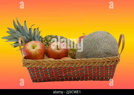 Ein exotischer Obstkorb auf orange-gelbem Hintergrund Stockfoto
