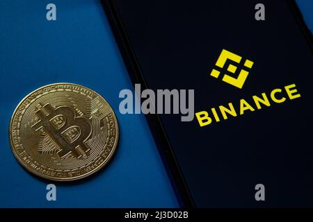 Logo der mobilen Binance-Anwendung auf dem Smartphone-Bildschirm. Goldene Bitcoin-Münze. Afyonkarahisar, Türkei - 6. April 2022. Stockfoto