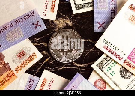 Bitcoin Kryptowährung Münze neben dem US-Dollar russischen und weißrussischen Rubel Stockfoto