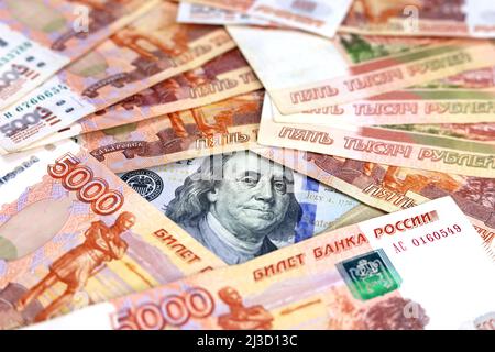 US-Dollar umgeben von russischen Rubel. Konzept des Wechselkurses, amerikanische Sanktionen gegen Russland Stockfoto