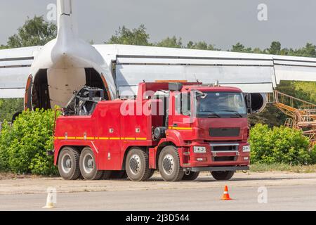 Leistungsstarke große Rig Semi-Truck-Traktor Schleppflugzeug im Hintergrund am Flughafen Stockfoto