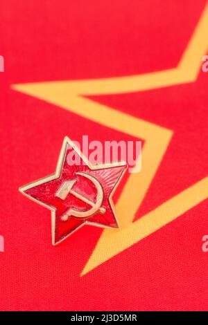 Abzeichen aus der Zeit des sowjetischen Russland mit Hammer und Sichel und roter Sternkappe auf der Flagge der kommunistischen Ära aus Stoff. Ein Symbol der Unterdrückung für viele unter dem Daumen der UdSSR. Stockfoto