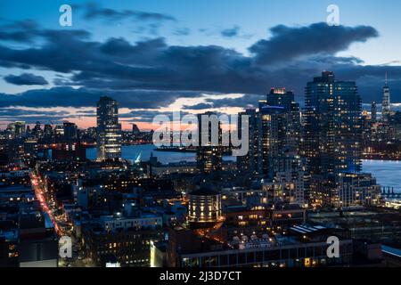 Blick auf die Skyline von Manhattan/Brooklyn bei Sonnenuntergang, aufgenommen von einem Dach in Williamsburg, Brooklyn, New York, Vereinigte Staaten von Amerika (USA) Stockfoto