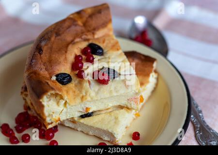 Köstliche Brocken Quark-Auflauf mit Rosinen und Johannisbeeren aus nächster Nähe auf einem Teller Stockfoto