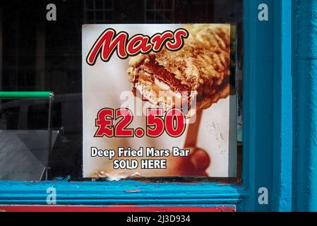 Werbespot für frittierte Mars Bar im Fenster eines Fisch- und Chipshops in Edinburgh. Stockfoto