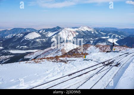 Pikes Peak Summit bedeckt mit Schnee, die Broadmoor Manitou und Pikes Peak Cog Railway Tracks sichtbar. Stockfoto