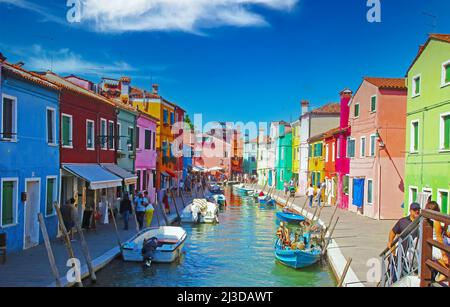 Venedig (Burano), Italien - Mai 9. 2019: Malerischer Blick von der tre ponti Brücke auf den Wasserkanal mit Booten, farbenfrohe, helle Häuser am Wasser, klares Blau Stockfoto
