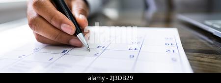 Kalendertermin. Junger Mann Hält Pen Marking Datum Stockfoto