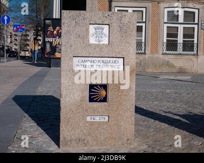 VILA REAL, PORTUGAL - 02. April 2022: Jakobsmuschel-Keramikwegschild auf der steinernen Granitstele in der Vila Real, Portugal. Stockfoto