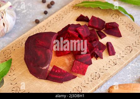 Rote Rüben in Scheiben geschnitten mit Knoblauch, Zwiebeln und Gewürzen - Zubereitung fermentierter Kvass Stockfoto