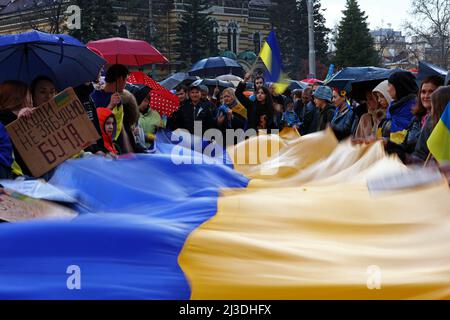 Sofia, Bulgarien - 7. April 2022: Menschen demonstrieren während eines marsches zur Unterstützung der Ukraine mit der Nationalflagge der Ukraine. Am 24.. Februar betrat die russische Armee das ukrainische Territorium, als der russische Präsident Wladimir Putin eine "besondere Militäroperation" erklärte. Stockfoto