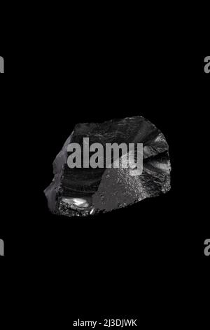 Das obsidische, vulkanische Glas auf schwarzem Hintergrund. Stockfoto