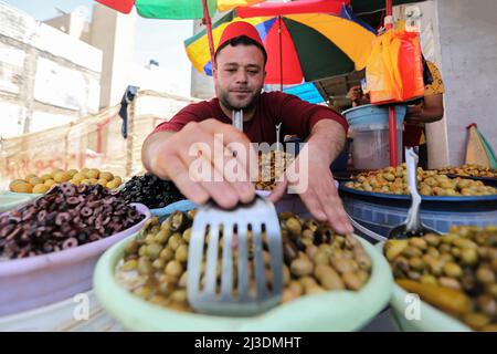 Während des heiligen Monats Ramadan kaufen Palästinenser im Lager Khan Yunis im südlichen Gazastreifen auf einem Markt ein, während die Preise infolge der russischen Invasion in die Ukraine stiegen. Palästina. Stockfoto