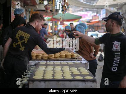 Während des heiligen Monats Ramadan kaufen Palästinenser im Lager Khan Yunis im südlichen Gazastreifen auf einem Markt ein, während die Preise infolge der russischen Invasion in die Ukraine stiegen. Palästina. Stockfoto