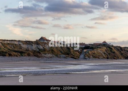 Ein farbenfroher, dramatischer Sonnenuntergang am Meer, Landschaft mit einer kleinen Stadt auf einer Klippe im Hintergrund am Ufer des Cap Blanc-Nez, Frankreich. Hochwertige Fotos Stockfoto