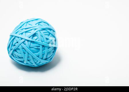 Nahaufnahme eines einzelnen blauen Balles mit vielen Gummibändern auf weißem Hintergrund Stockfoto