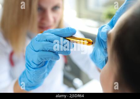 Der Augenarzt strahlt Licht in die Augen des Patienten Stockfoto