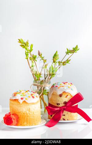 Köstliche Oster-Kuchen mit Band und Blumen auf weißem Hintergrund dekoriert. Festliche Speisen. Stockfoto