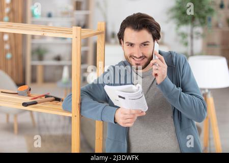 frustriert Mann Zusammenstellung Selbstmontage Möbel Stockfoto