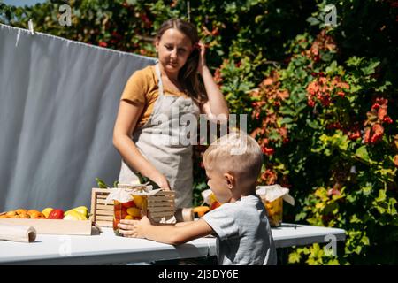 Konservierung Gartengemüse, Konservierung von Tomaten, Paprika, Zucchini-Gemüse. Fermentierte Lebensmittel. Familie Mutter und Kind Konserven Gemüse in der Stockfoto